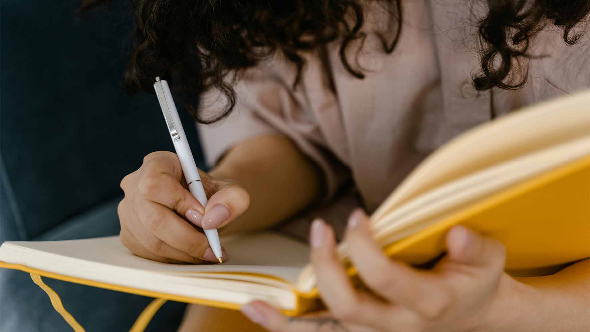 Jeune femme écrivant dans son bullet journal Lunesquisse